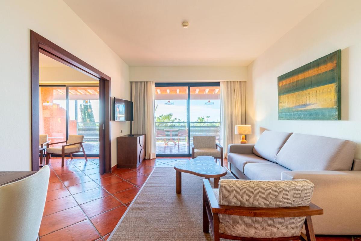 una sala de estar con un sofá y una mesa en Puerto Antilla Grand Hotel, en Islantilla