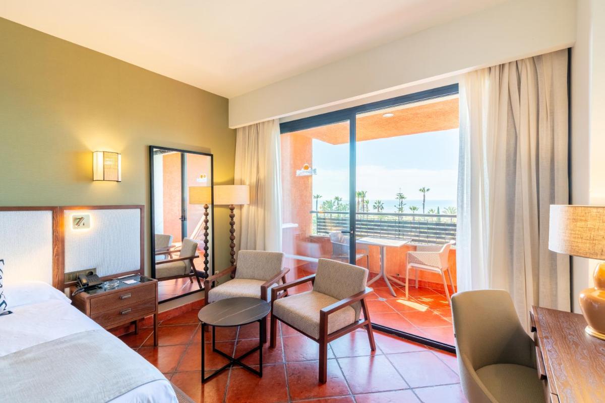 una habitación de hotel con una cama y un balcón en Puerto Antilla Grand Hotel, en Islantilla