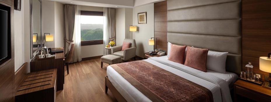 a hotel room with a large bed and a window at Jaypee Vasant Continental in New Delhi +80 photos