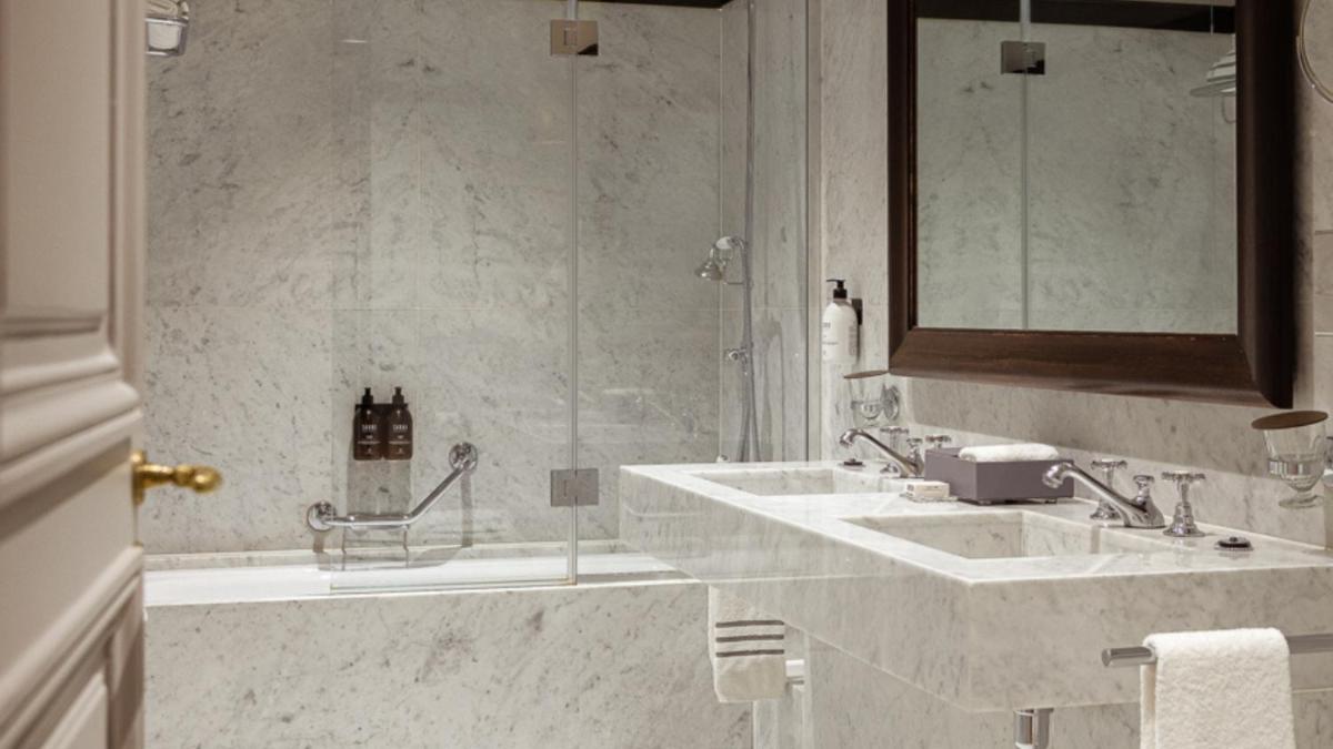 une salle de bain avec deux lavabos et une douche dans l'établissement Hôtel Lancaster Paris Champs-Elysées, à Paris 37 autres photos