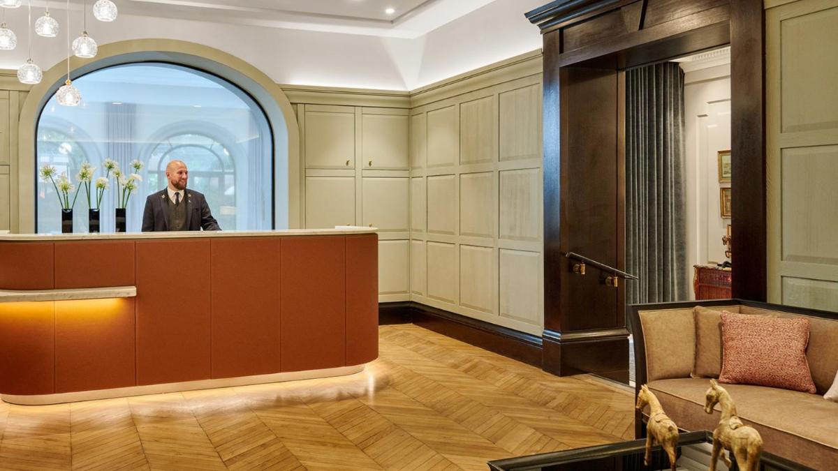Un homme debout derrière un podium dans un hall dans l'établissement Hôtel Lancaster Paris Champs-Elysées, à Paris