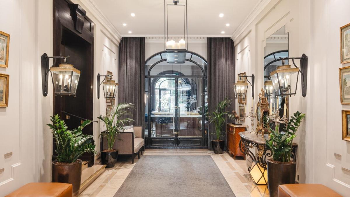 un couloir avec des plantes en pot et une porte dans l'établissement Hôtel Lancaster Paris Champs-Elysées, à Paris