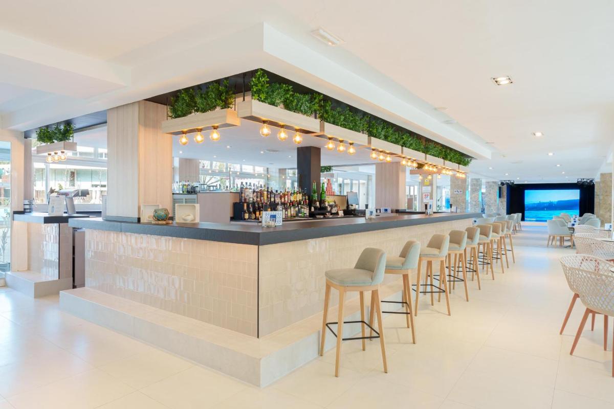 una barra en un restaurante con taburetes en Ferrer Janeiro Hotel & Spa, en Can Picafort