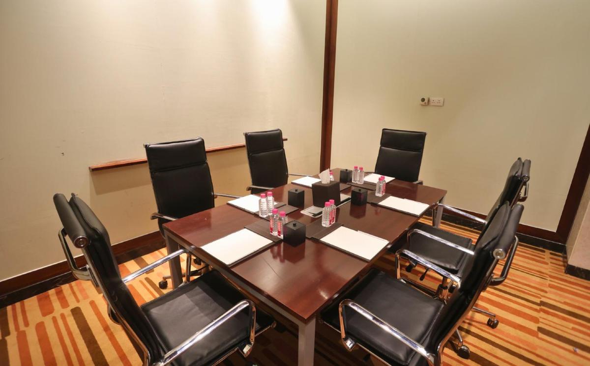 a conference room with a wooden table and black chairs at InterContinental Jaipur Tonk Road by IHG in Jaipur