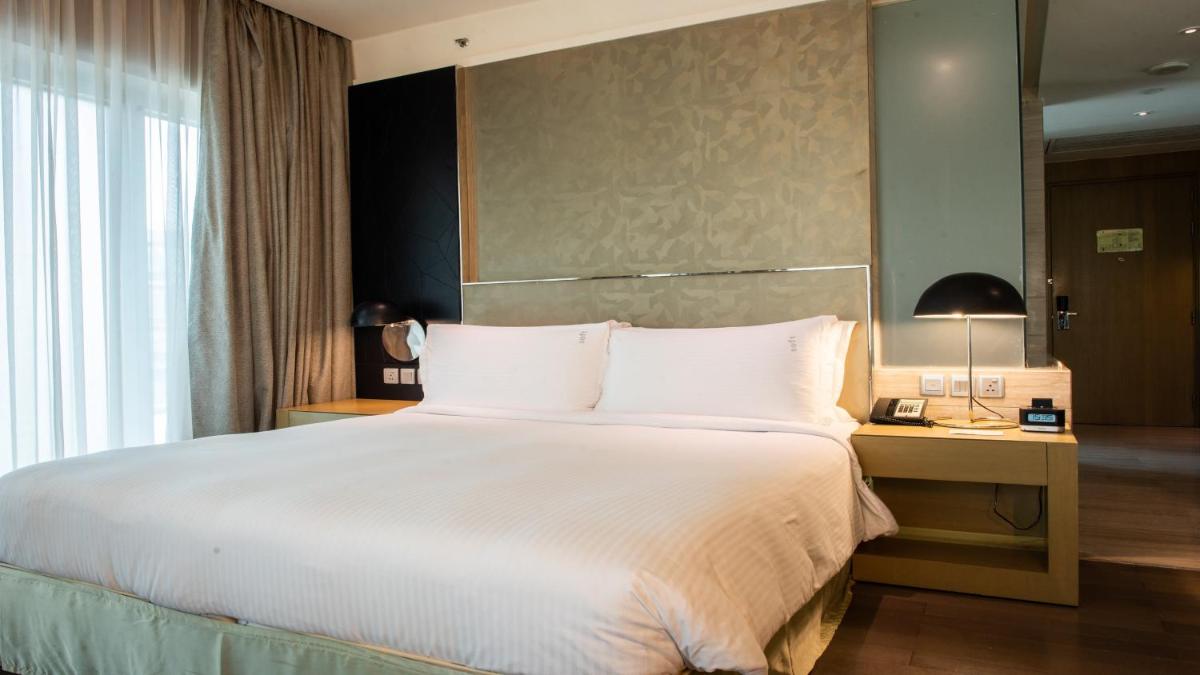 a bedroom with a large bed and a desk with a lamp at Holiday Inn New Delhi Aerocity by IHG in New Delhi