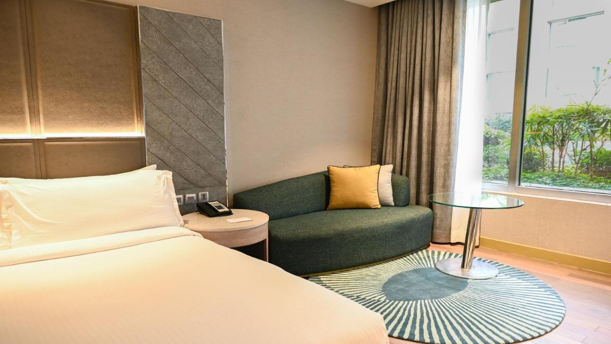a hotel room with a bed and a couch at Holiday Inn New Delhi Aerocity by IHG in New Delhi