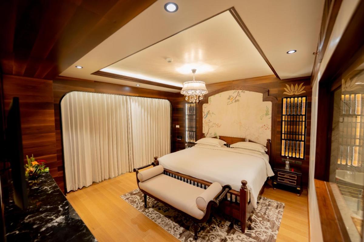 a bedroom with a large bed and a chandelier at Taj Tirupati in Tirupati