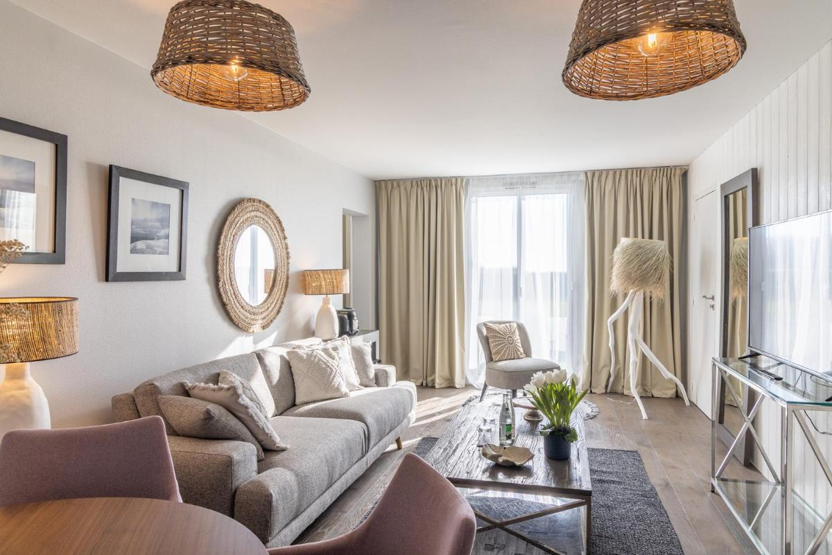 un salon avec un canapé et une télévision dans l'établissement Hôtel Atalante - Relais Thalasso & Spa, à Sainte-Marie de Ré