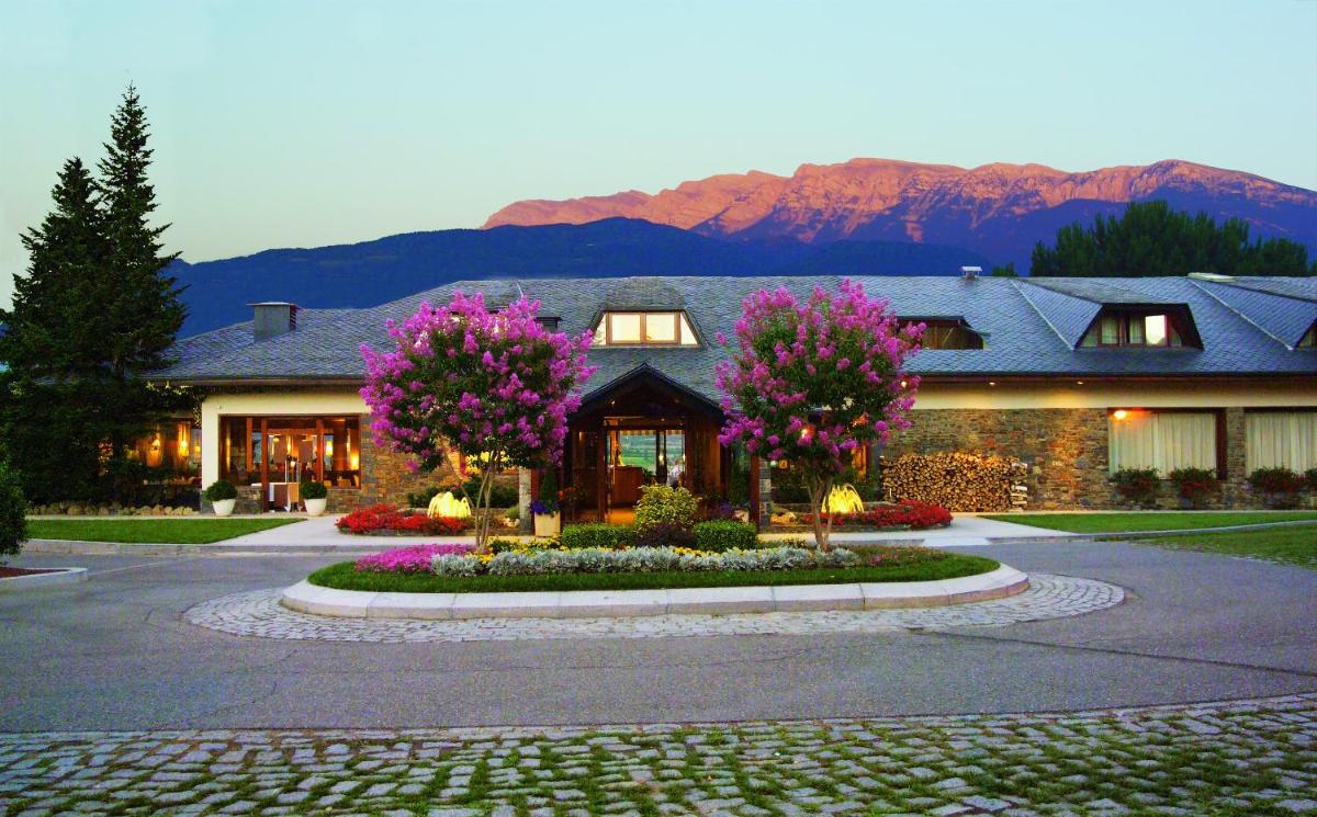 una casa con flores rosas delante de ella en HOTEL & SPA El Castell de Ciutat, en La Seu d'Urgell