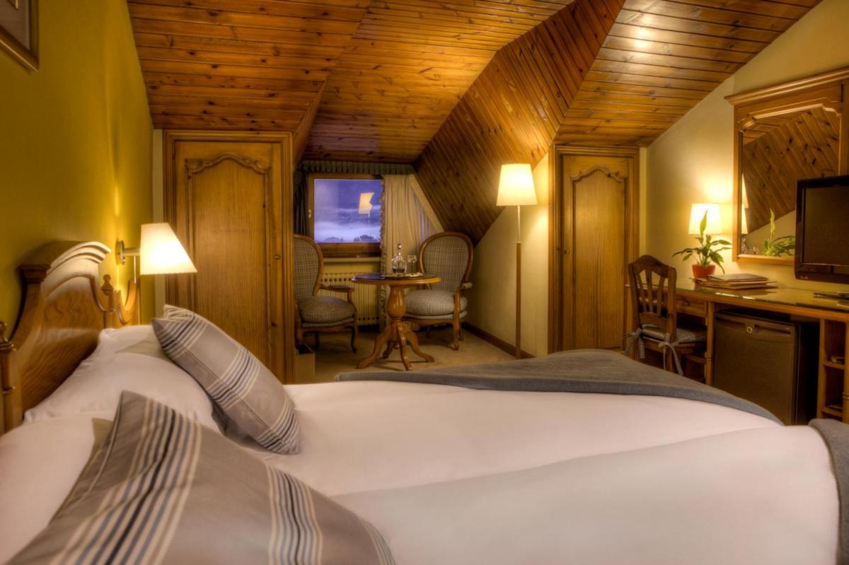 Un dormitorio con una cama, un escritorio y una mesa. en HOTEL & SPA El Castell de Ciutat, en La Seu d'Urgell 23 fotos más