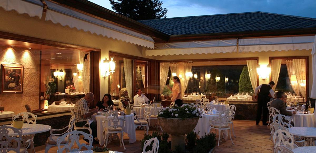un grupo de personas sentadas en mesas en un restaurante en HOTEL & SPA El Castell de Ciutat, en La Seu d'Urgell