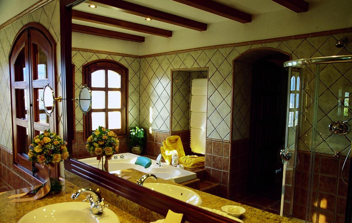 Un baño con lavabo, bañera y espejo. en HOTEL & SPA El Castell de Ciutat, en La Seu d'Urgell