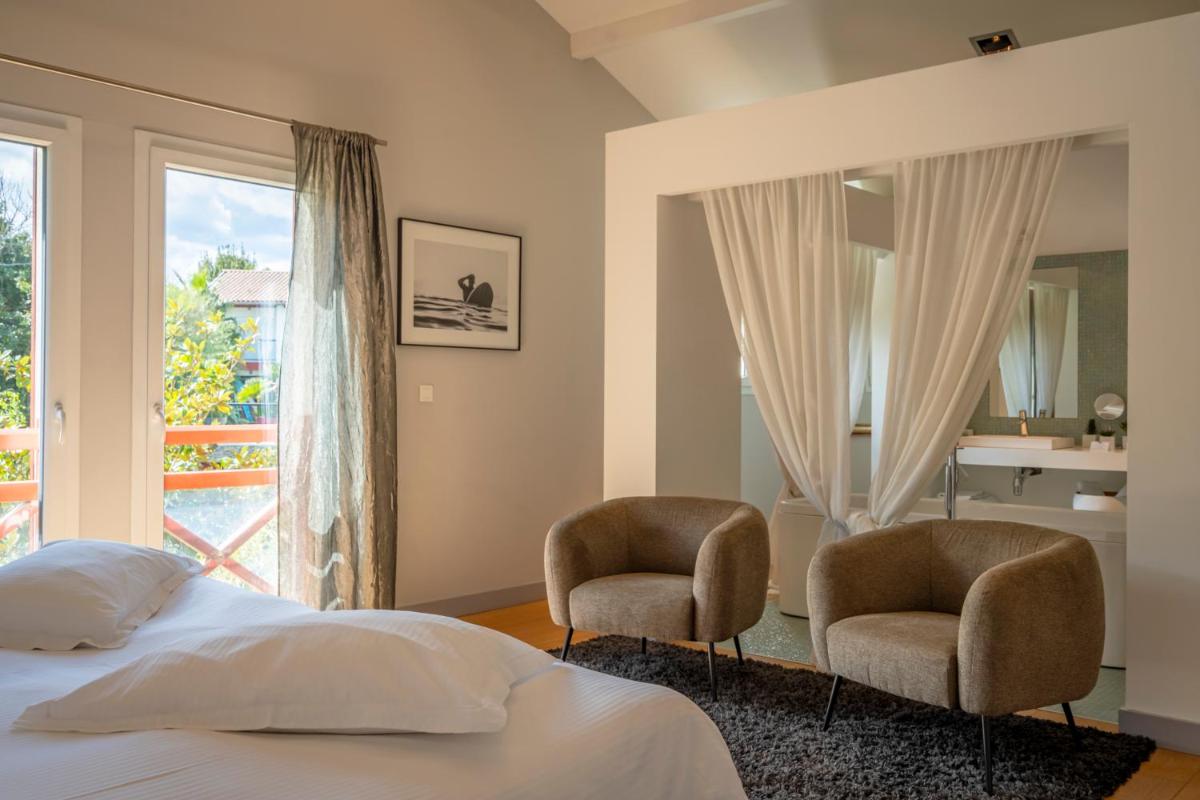 - une chambre avec deux chaises, un lit et une fenêtre dans l'établissement Lafitenia Resort, à Saint-Jean-de-Luz 37 autres photos