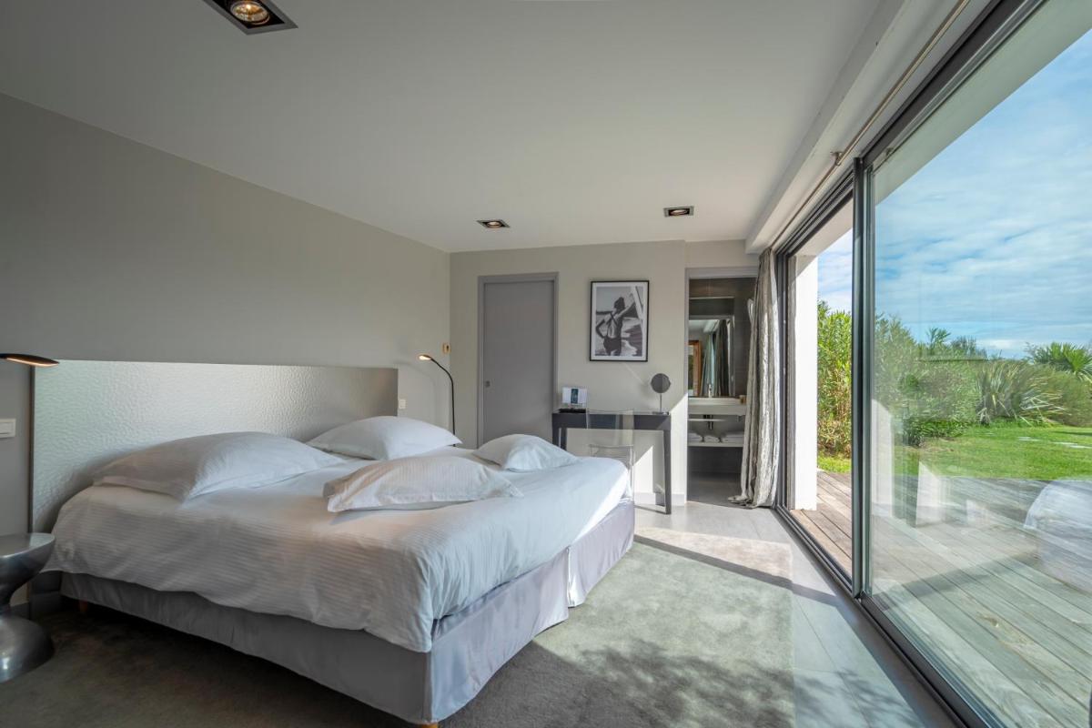 une chambre avec un grand lit et une grande fenêtre dans l'établissement Lafitenia Resort, à Saint-Jean-de-Luz