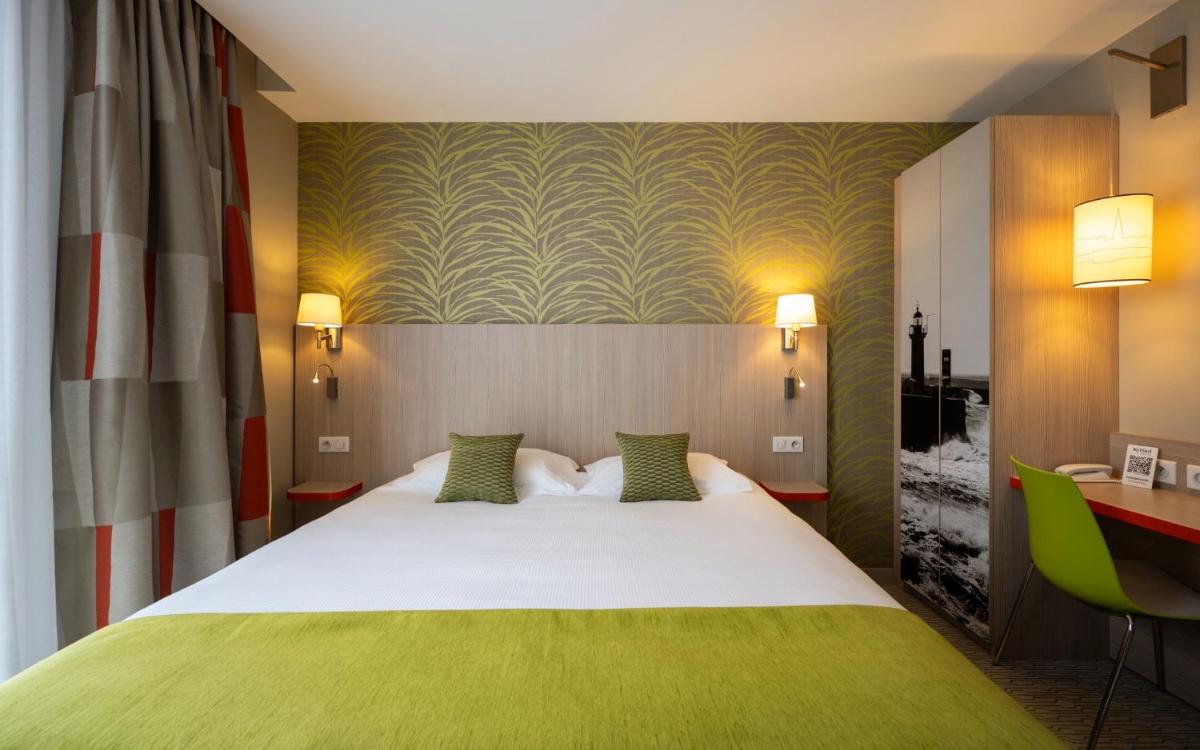 une chambre d'hôtel avec un lit et un bureau dans l'établissement Kyriad Prestige Saint-Malo, à Saint-Malo