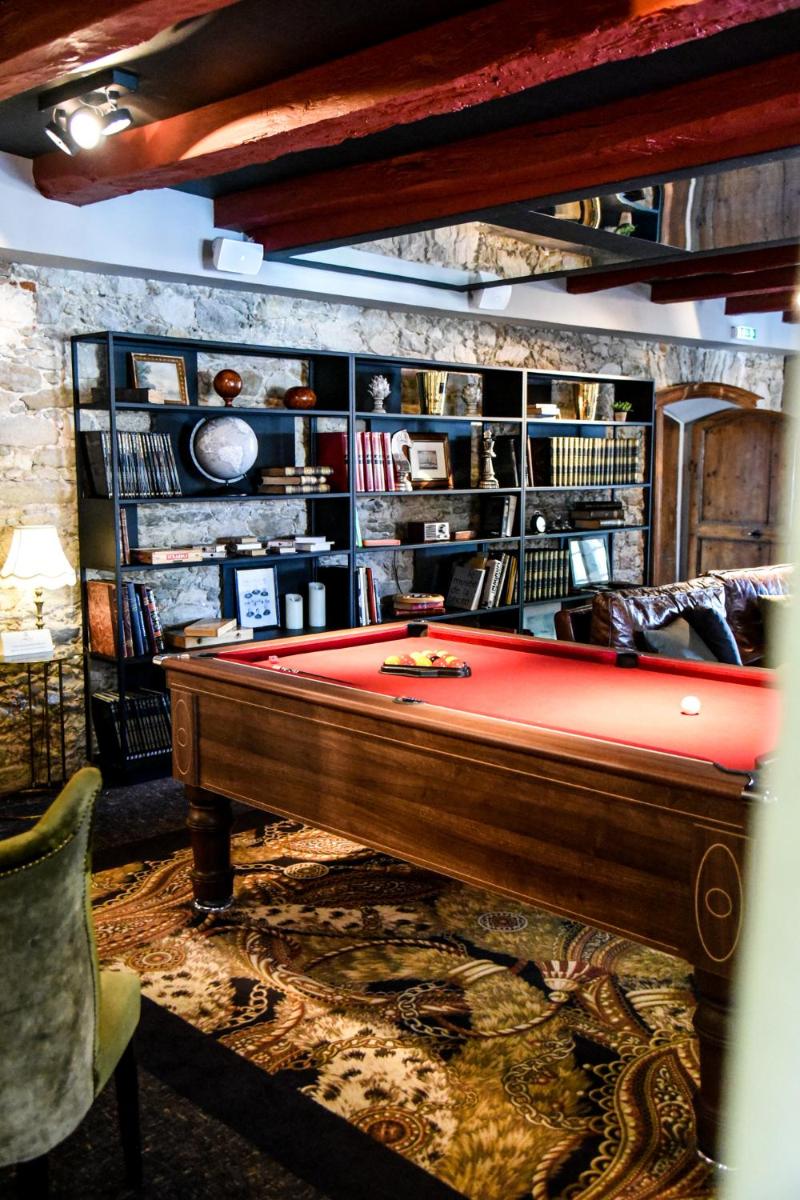 une salle avec une table de billard devant une bibliothèque dans l'établissement Le Général d'Elbée Hotel & Spa - Teritoria, à Noirmoutier-en-l'lle