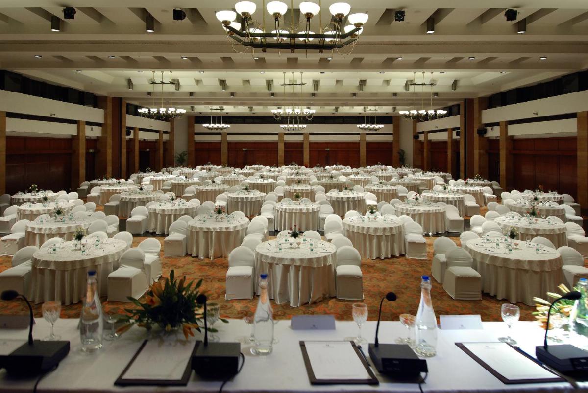 a large banquet hall with white tables and chairs at Jaypee Palace Hotel in Agra