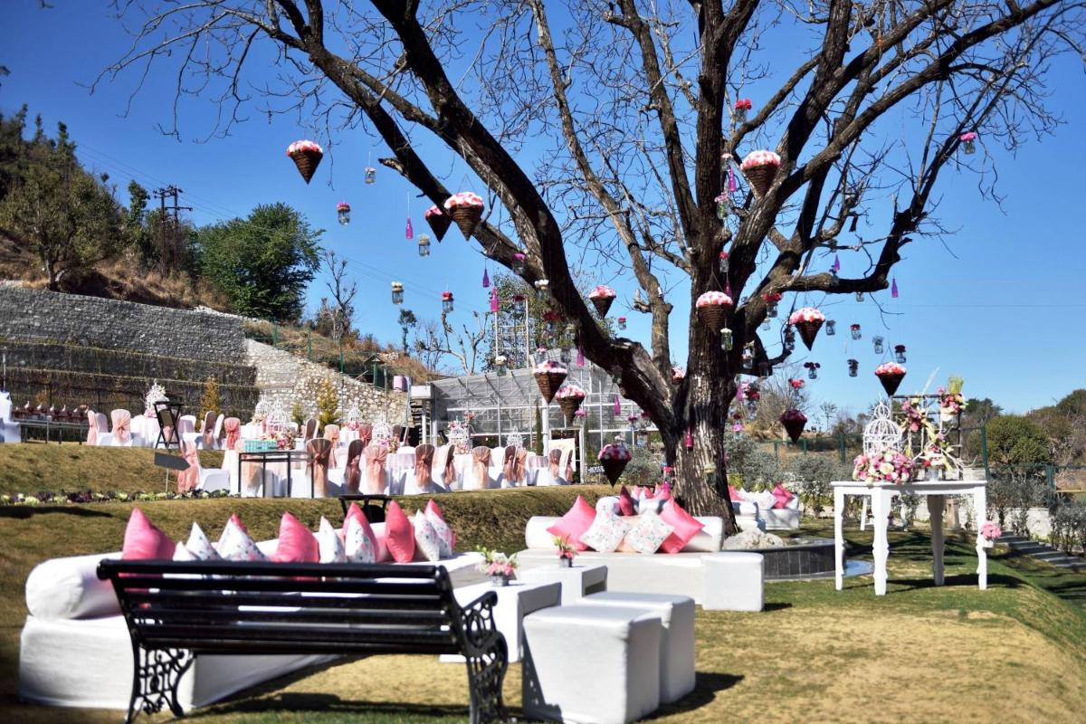 a park with a bench and a tree with pink pillows at JW Marriott Mussoorie Walnut Grove Resort & Spa in Mussoorie