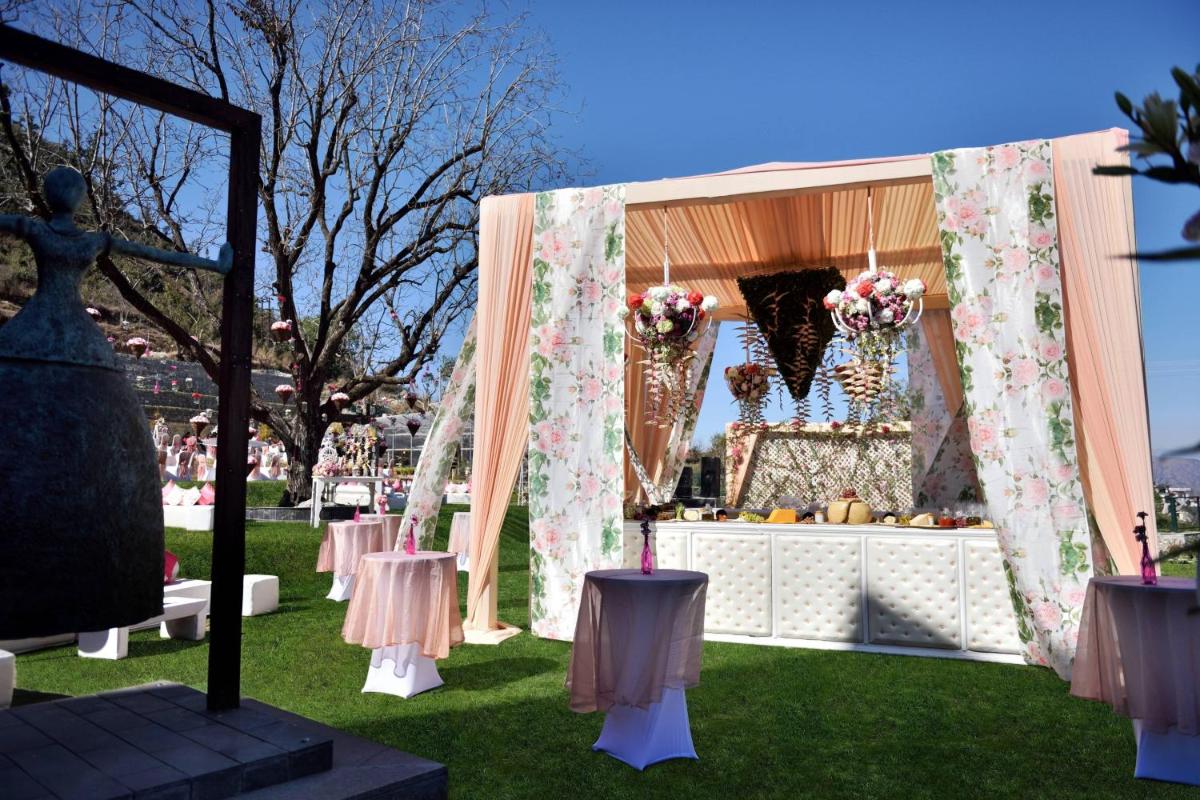 a gazebo with pink and white tables and flowers at JW Marriott Mussoorie Walnut Grove Resort & Spa in Mussoorie