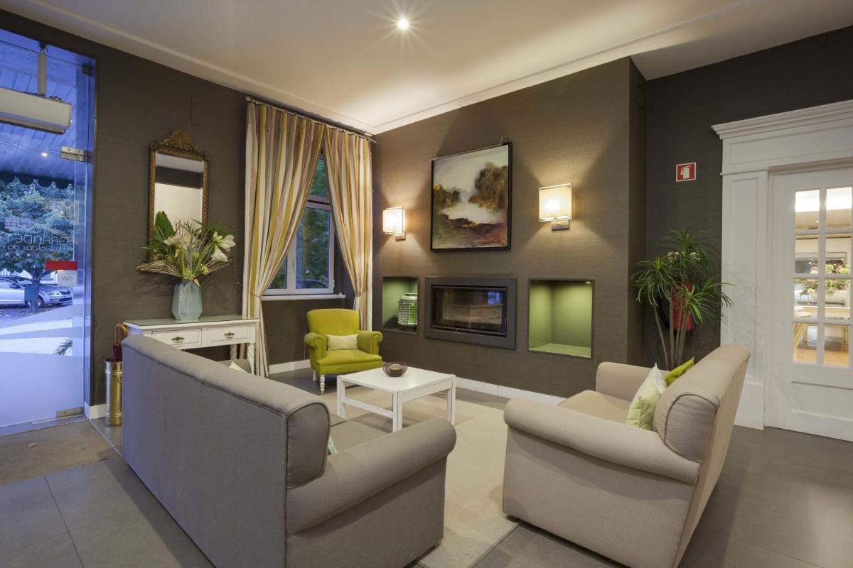 uma sala de estar com duas cadeiras e um sofá em Grande Hotel das Caldas da Felgueira nas Caldas da Felgueira