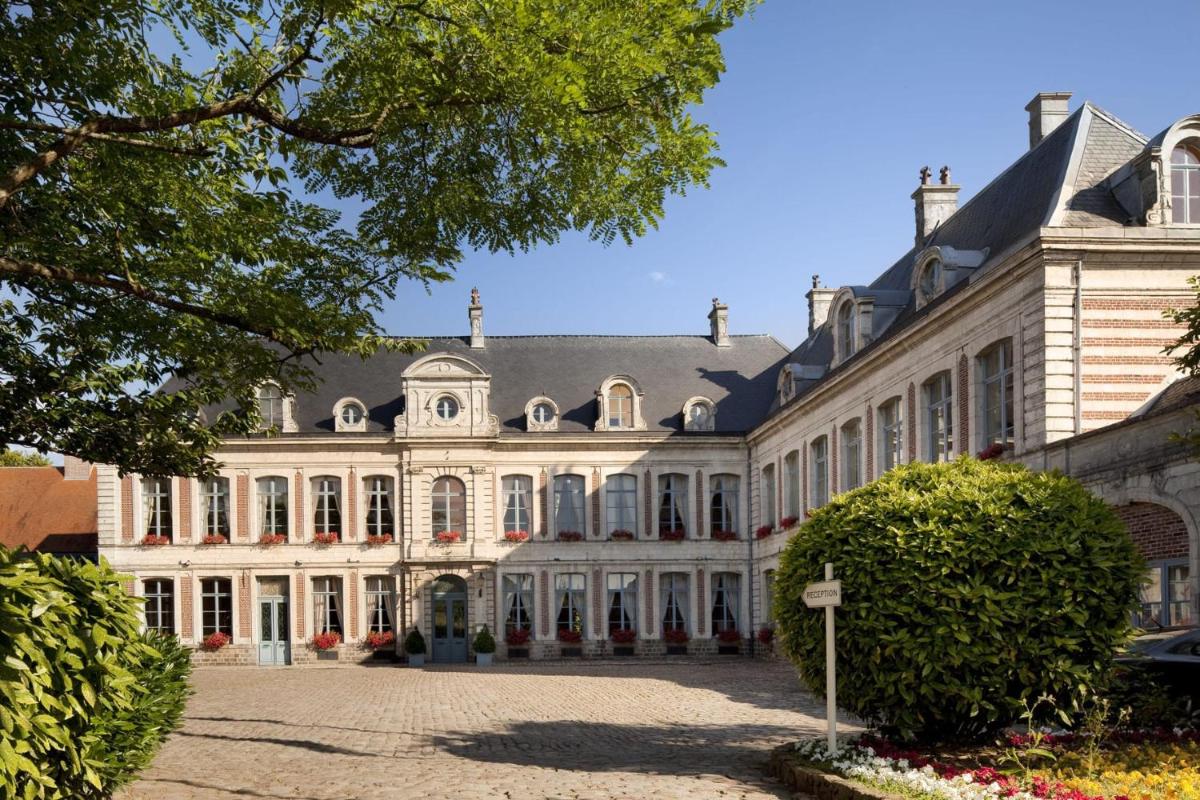 un grand bâtiment blanc avec une grande cour dans l'établissement La Chartreuse Du Val Saint Esprit, à Gosnay