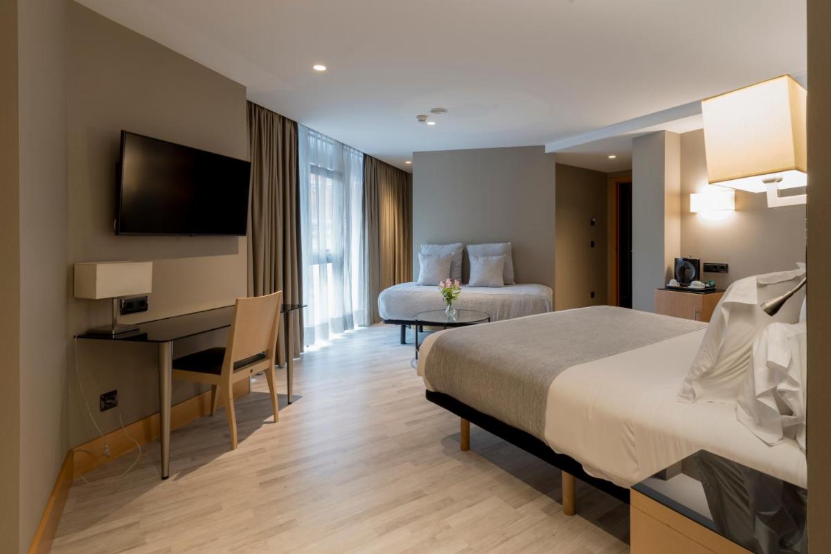 una habitación de hotel con una cama y un escritorio en Hotel Plaza, en A Coruña