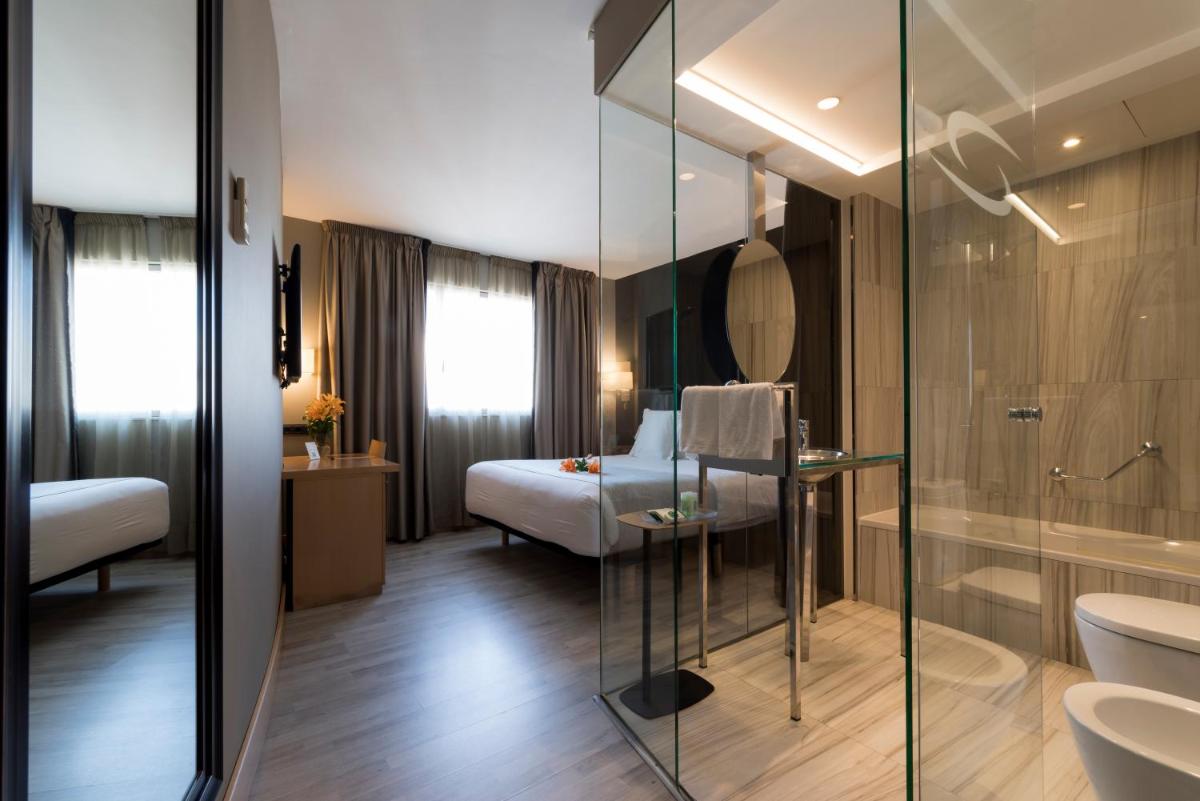 1 dormitorio y baño con ducha acristalada. en Hotel Plaza, en A Coruña