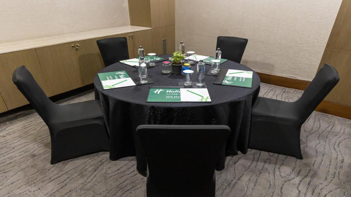 a black table with black chairs in a room at Holiday Inn New Delhi Aerocity by IHG in New Delhi
