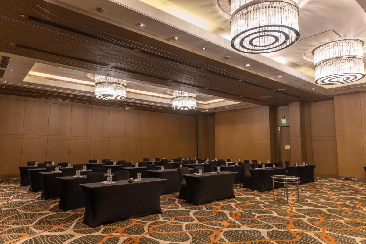 a large banquet hall with tables and chandeliers at Holiday Inn New Delhi Aerocity by IHG in New Delhi