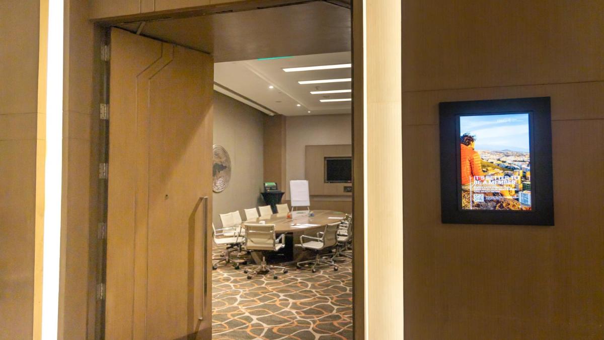 a conference room with a table and a tv on the wall at Holiday Inn New Delhi Aerocity by IHG in New Delhi