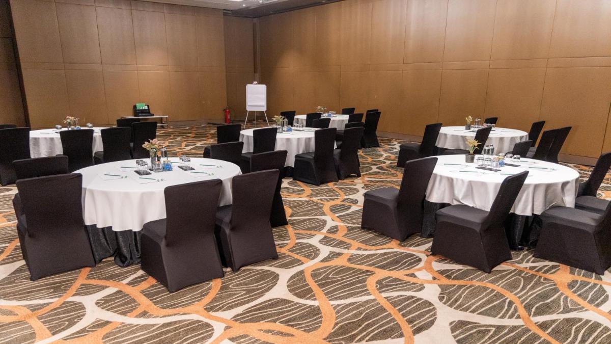 a banquet hall with tables and chairs with white table cloth at Holiday Inn New Delhi Aerocity by IHG in New Delhi