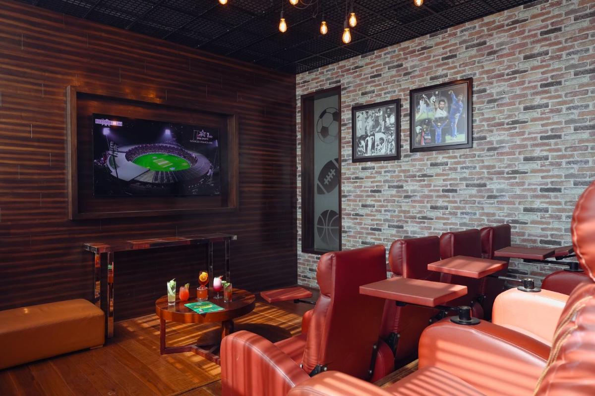 a waiting room with red chairs and a tv at Holiday Inn Chennai OMR IT Expressway by IHG in Chennai