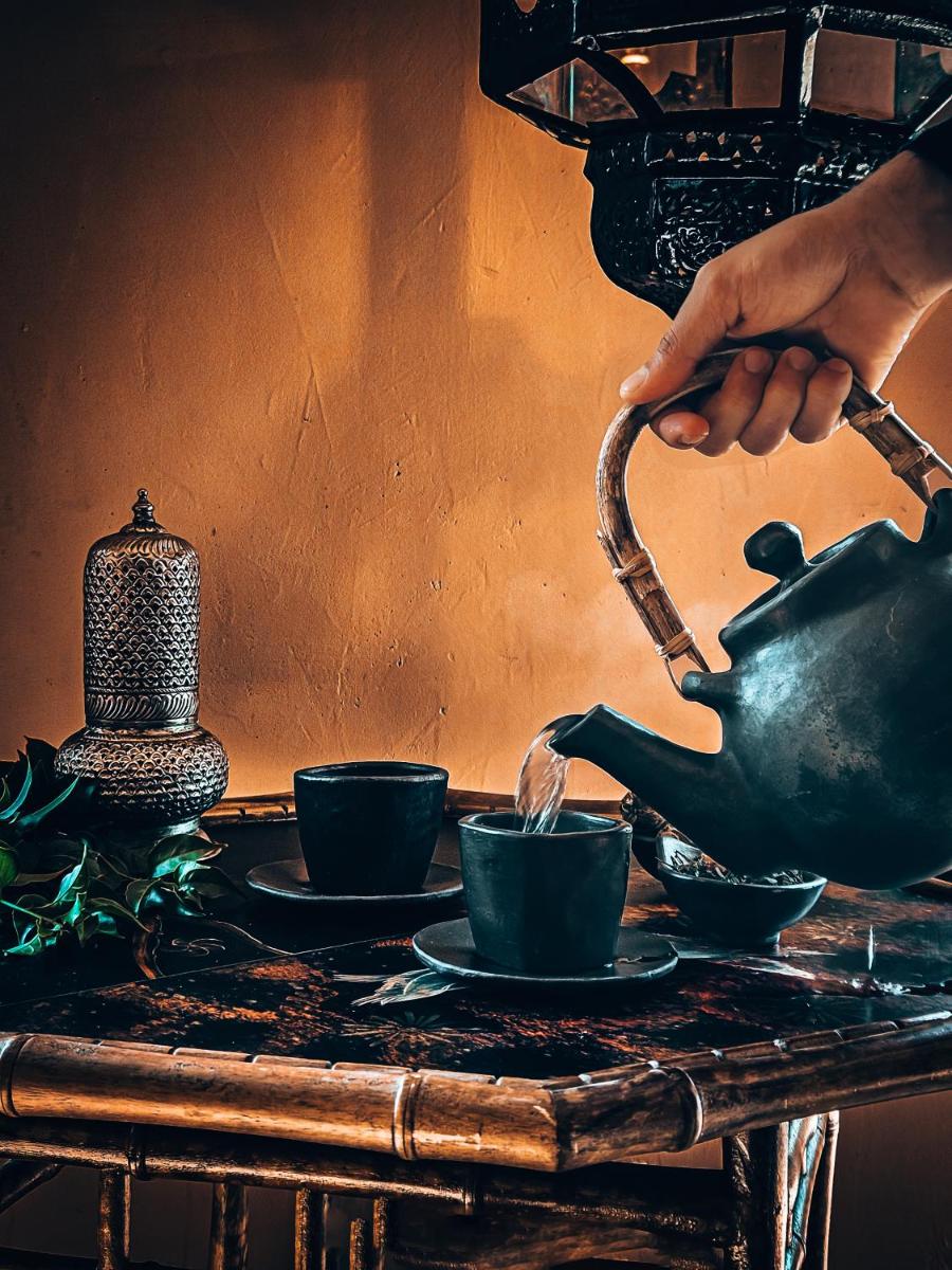 a person pouring coffee into cups on a table at Fairmont Jaipur in Jaipur