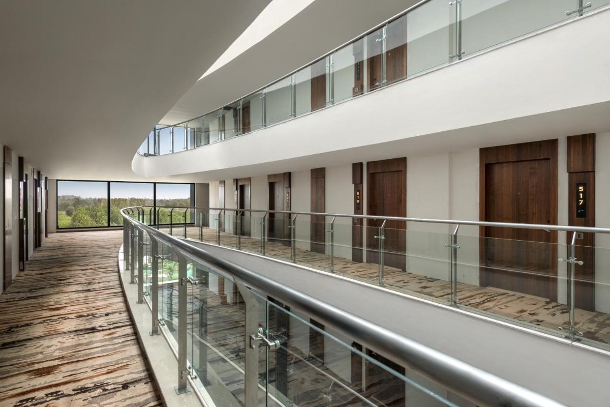 an empty corridor of a building with a balcony at Hyatt Place Haridwar in Haridwār