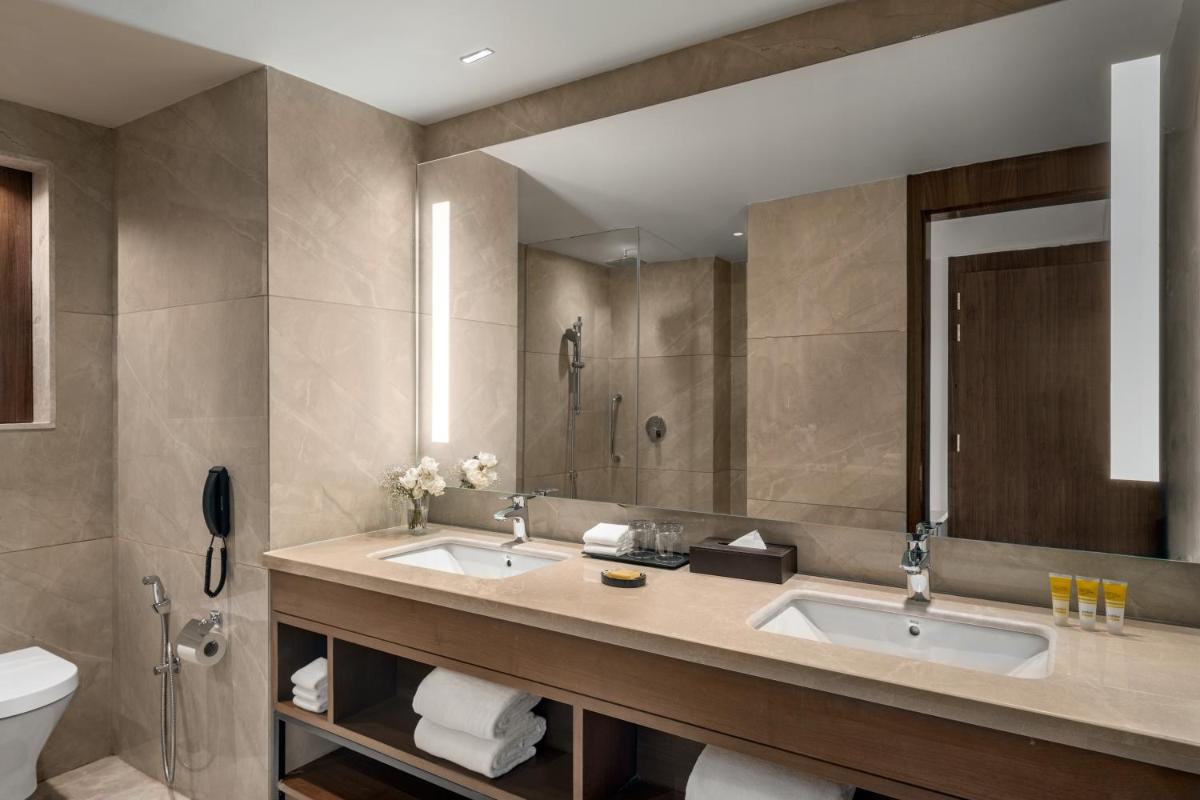 a bathroom with two sinks and a mirror at Hyatt Place Haridwar in Haridwār