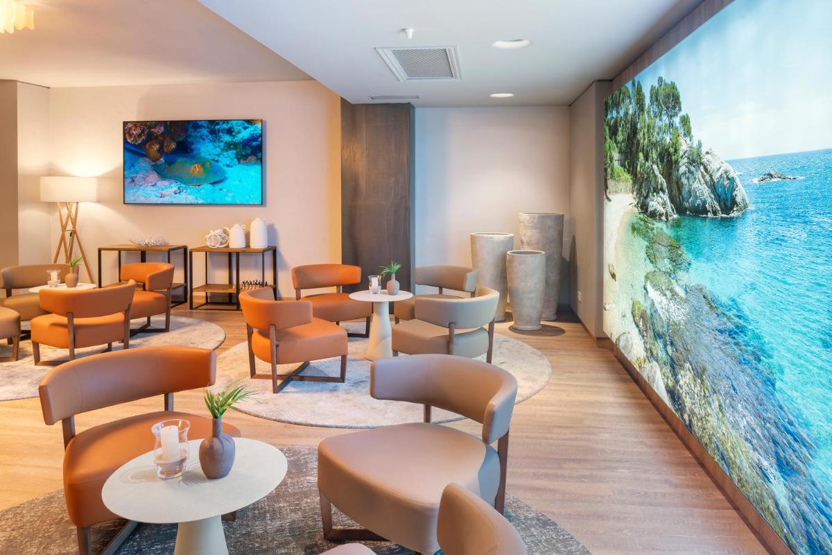 una sala de espera con una gran pintura en la pared en Hotel Cala del Pi - Adults Only, en Platja d'Aro