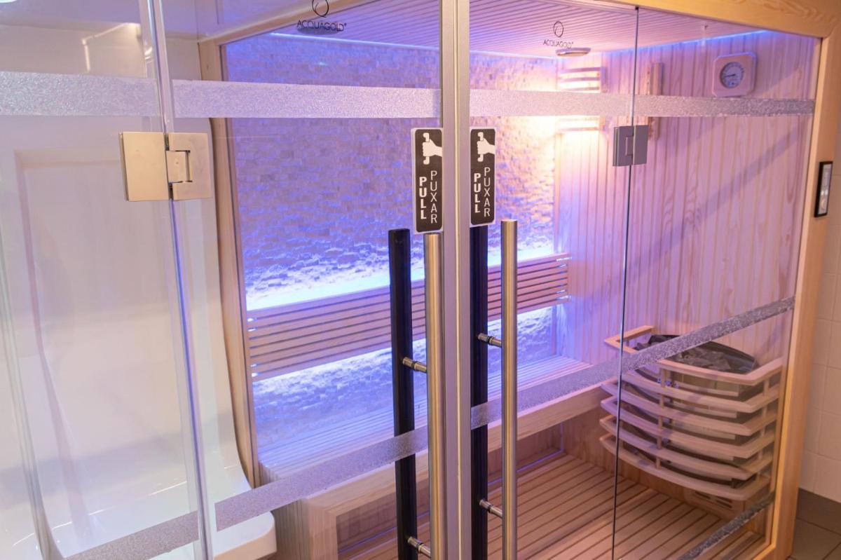 um chuveiro com porta de vidro em um banheiro em MASA Hotel & Spa Campo Grande Collection em Lisboa