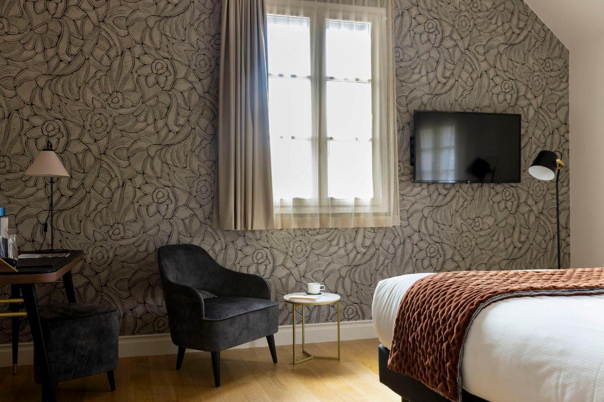 Télévision ou salle de divertissement dans l'établissement L'INVITATION AU VOYAGE - Hôtel & Spa