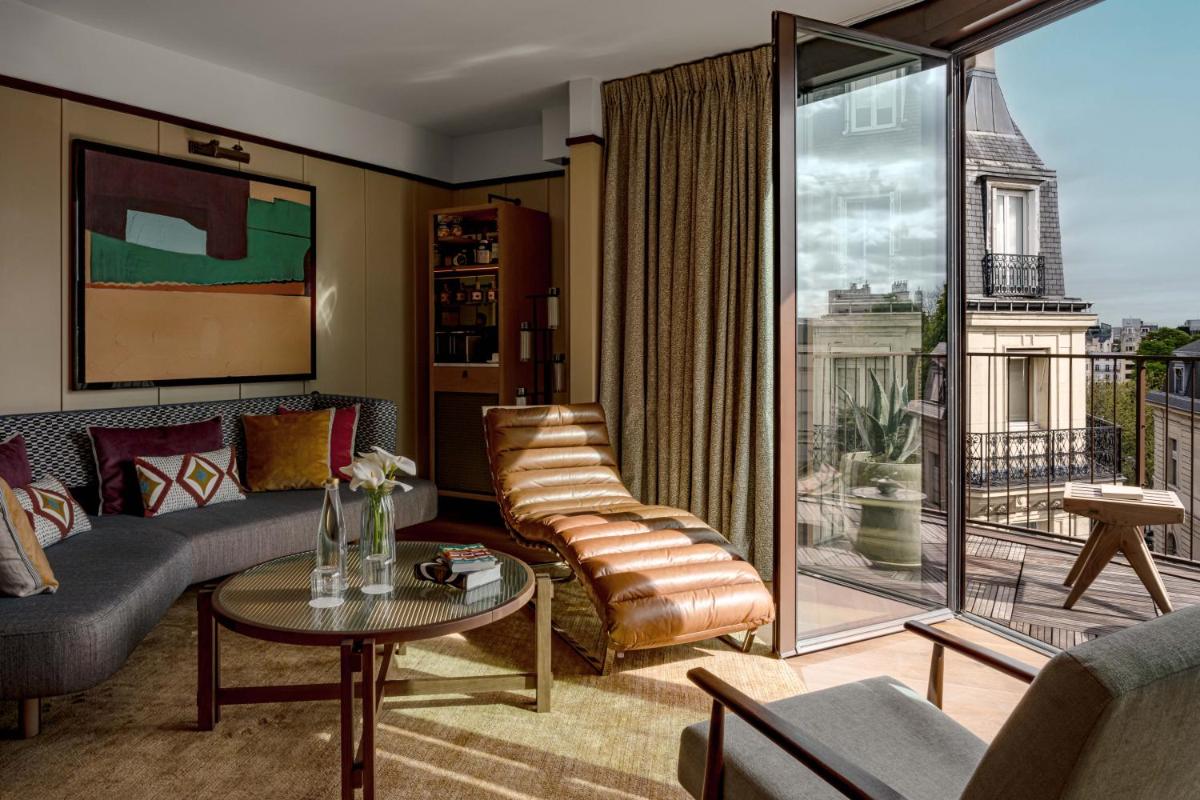 un salon avec un canapé et une table dans l'établissement Norman Paris Hôtel & Spa, à Paris