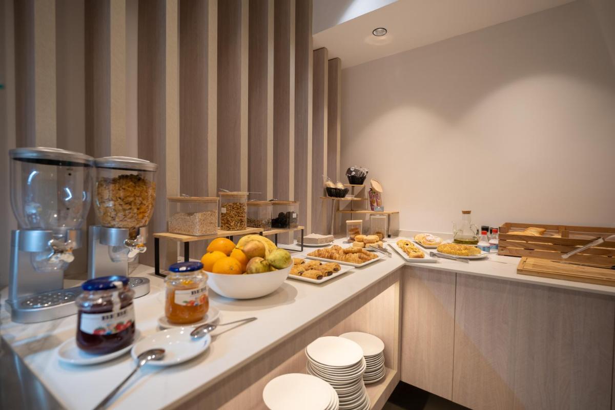 un desayuno buffet en una habitación de hotel con comida en Alfons Hotel, en Ciutadella