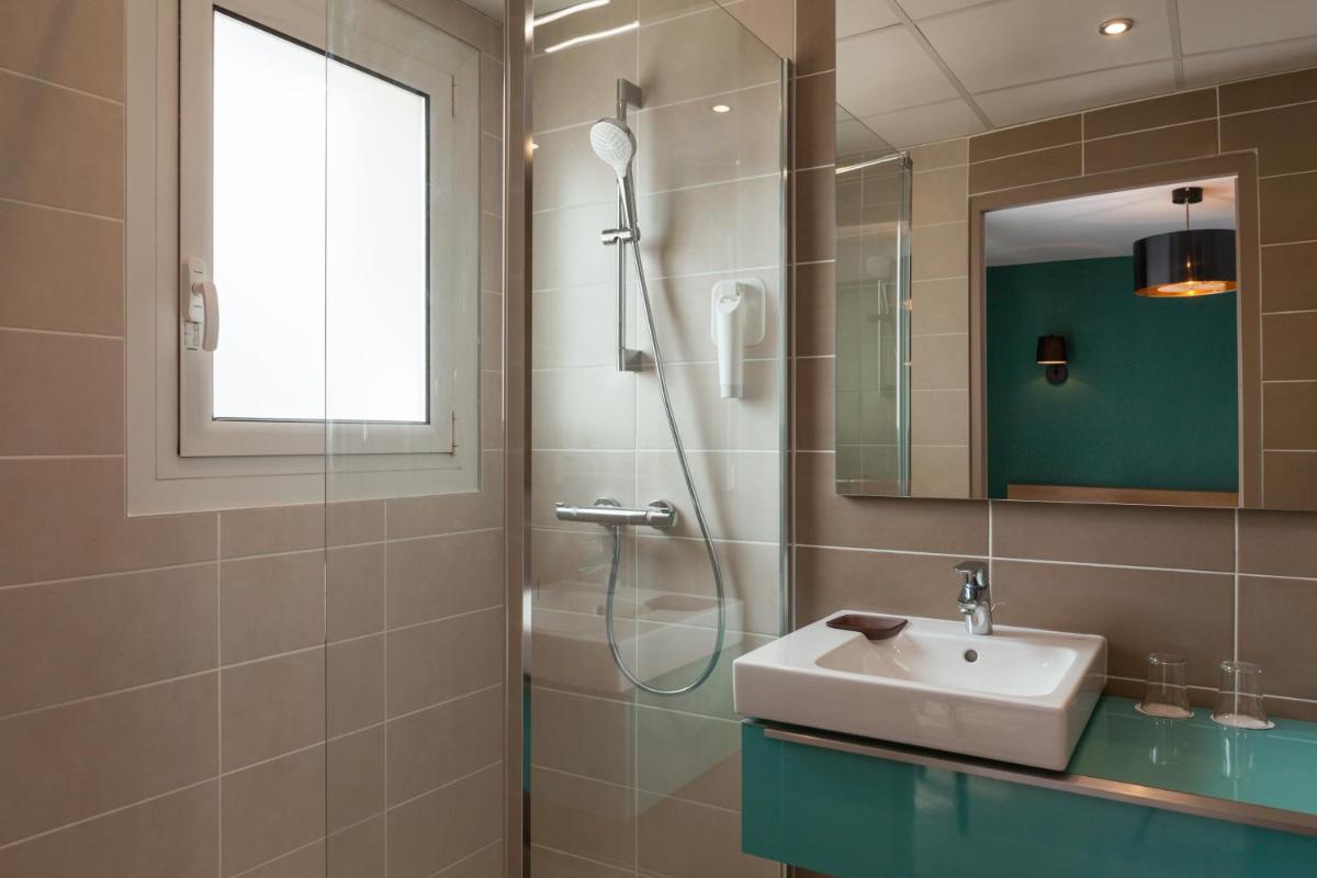 une salle de bain avec un lavabo et une douche dans l'établissement The Originals City, Hôtel Les Thermes de l'Avenue, Dax, à Dax