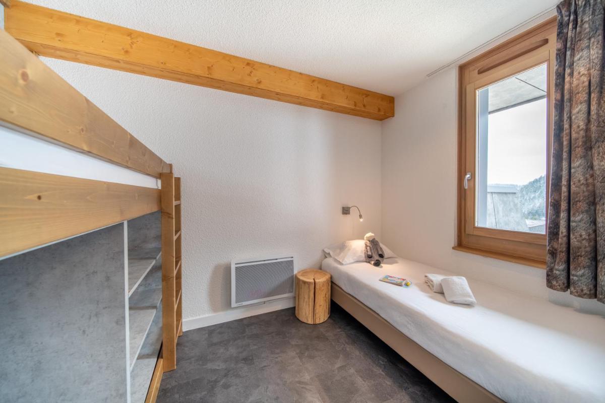 une chambre avec un lit superposé et une fenêtre dans l'établissement Résidence Kocoon Les Karellis - Pass activités inclus et accès gratuit et illimité à l'espace aquatique Aquarellis, à Montricher-Albanne