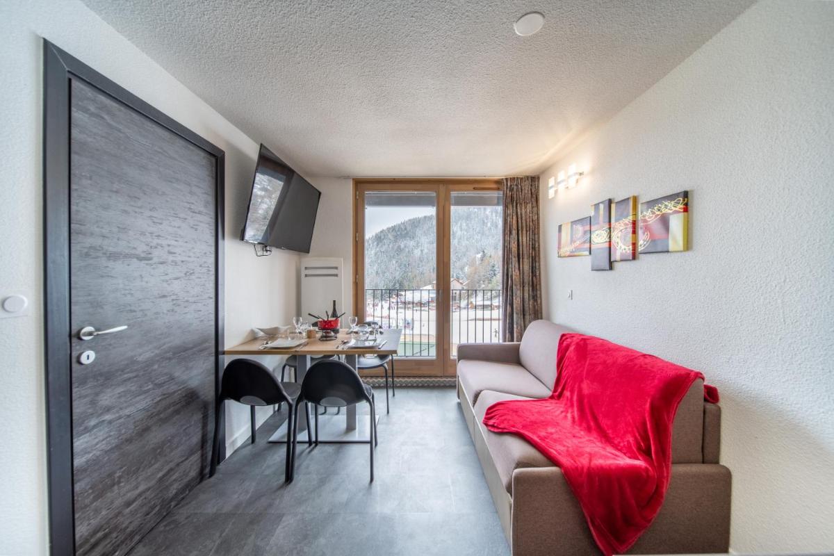 un salon avec un canapé et une table dans l'établissement Résidence Kocoon Les Karellis - Pass activités inclus et accès gratuit et illimité à l'espace aquatique Aquarellis, à Montricher-Albanne