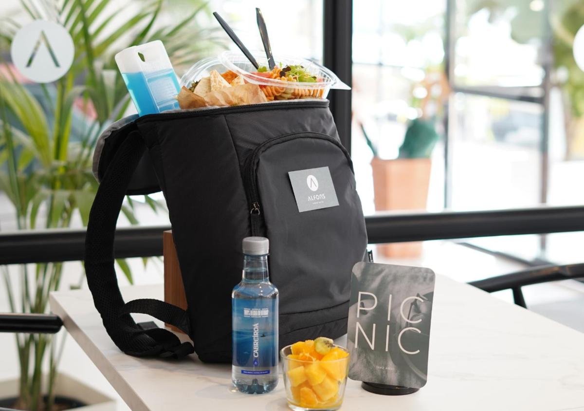 una mochila sentada en una mesa con una botella de agua en Alfons Hotel, en Ciutadella