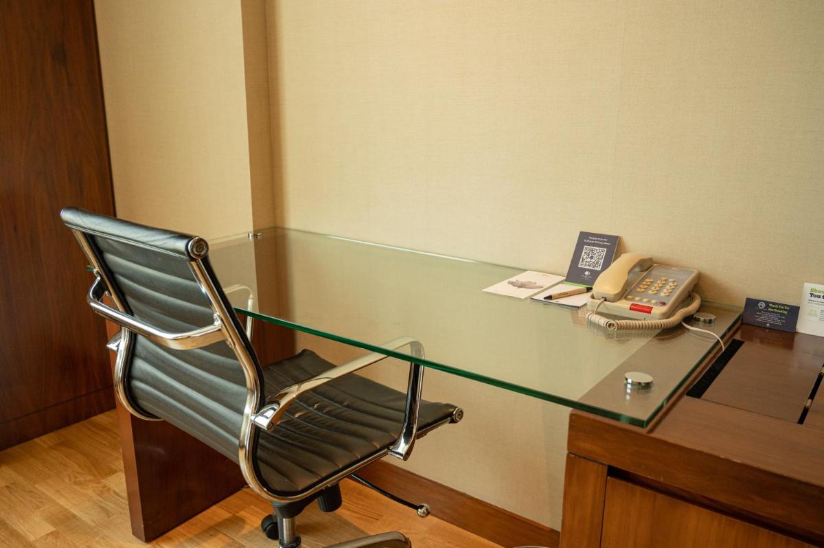a glass desk with a chair and a phone at DoubleTree by Hilton-Pune Chinchwad in Pune