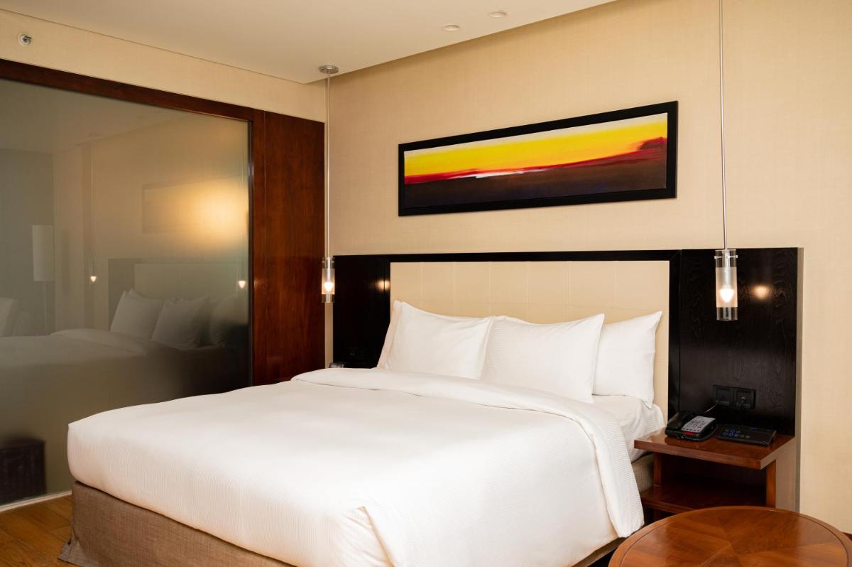 a bedroom with a large white bed and a table at DoubleTree by Hilton-Pune Chinchwad in Pune