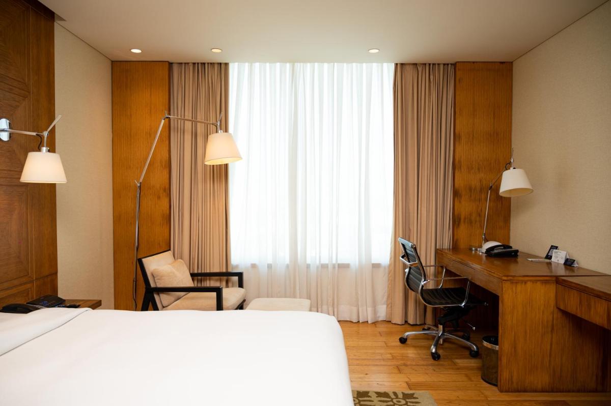 a hotel room with a bed and a desk and a desk at DoubleTree by Hilton-Pune Chinchwad in Pune