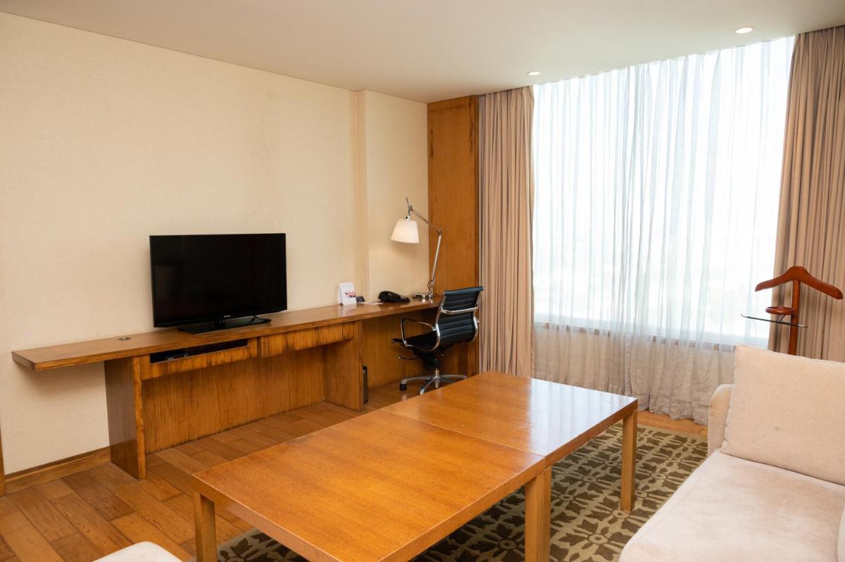 a hotel room with a desk with a television on it at DoubleTree by Hilton-Pune Chinchwad in Pune