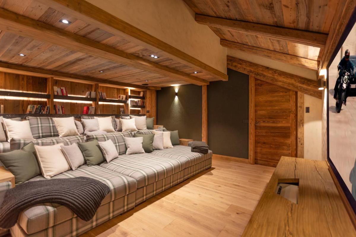 Cette chambre dispose de murs en bois et d'un grand canapé. dans l'établissement Armancette - The Leading Hotels of the World, à Saint-Gervais-les-Bains