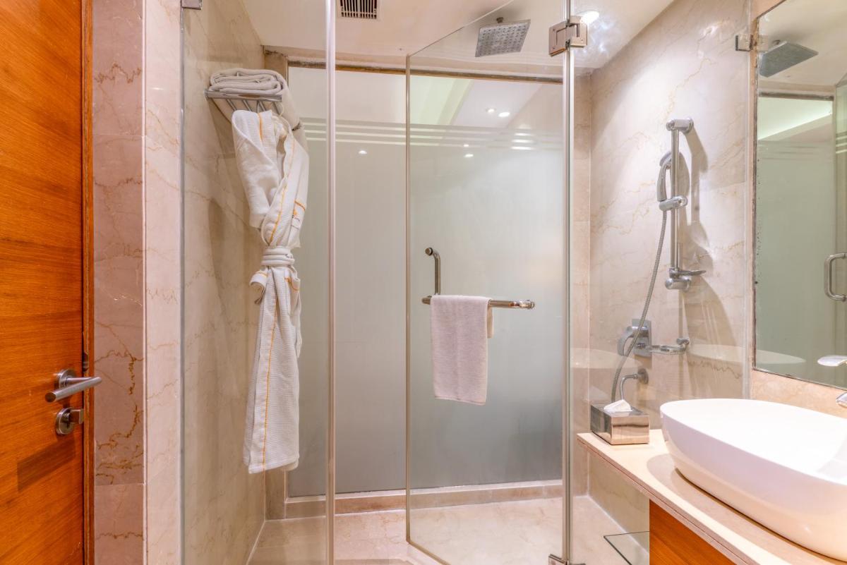 a bathroom with a shower and a sink at Pride Plaza Hotel, Kolkata in Kolkata